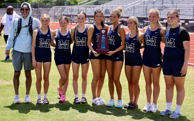 The McKeel girls track and field athletes pose with the runner-up trophy after finishing second in the team competition on Saturday at the Class 2A, District 9 meet at Tenoroc High School.