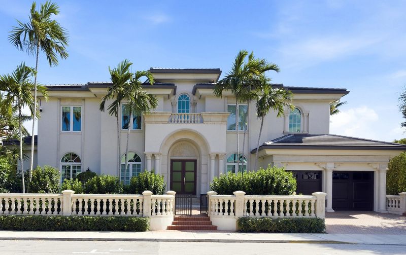 The house's Mediterranean-style exterior features a central archway that shelters the front doors.