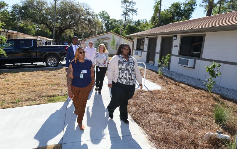 Visitors tour East Tumbling Creek following the ribbon-cutting for the newly renovated permanent supportive housing on April 21 in Gainesville. The facility is one of two former motels Alachua County purchased to provide low-cost supportive housing for people experiencing homelessness. Residents are expected to begin moving in on April 27.
