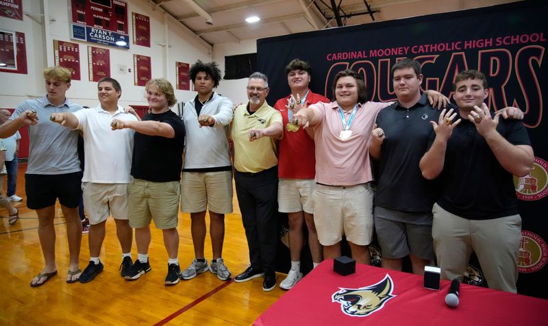 The offensive line poses for a group photo with their new championship rings. Cardinal Mooney Catholic High School held a ceremony Thursday evening, April 23, 2026, to present the football team with their state championship rings.