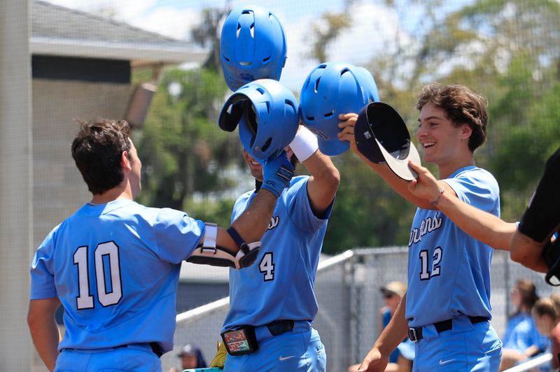 St. Johns Country Day's Hunter Rodgers (10) taps helmets with Preston Cole (4) and Aiden Flaschen (12) after a home run during the third inning of an FHSAA Region 1-1A first-round high school baseball playoff at St. Johns Country Day School, Saturday, April 25, 2026, in Orange Park, Fla. The St. Johns Country Day Spartans blanked the Rocky Bayou Christian Knights 15-0 in four innings.