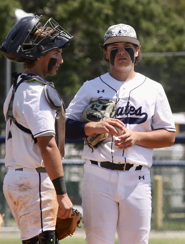 St. Edward's catcher Colton Freedman speaks with his older brother pitcher Caden Freedman in the Class 1A-Region 4 quarterfinals against Jupiter Christian Saturday at Blue Diamond Field in Vero Beach.