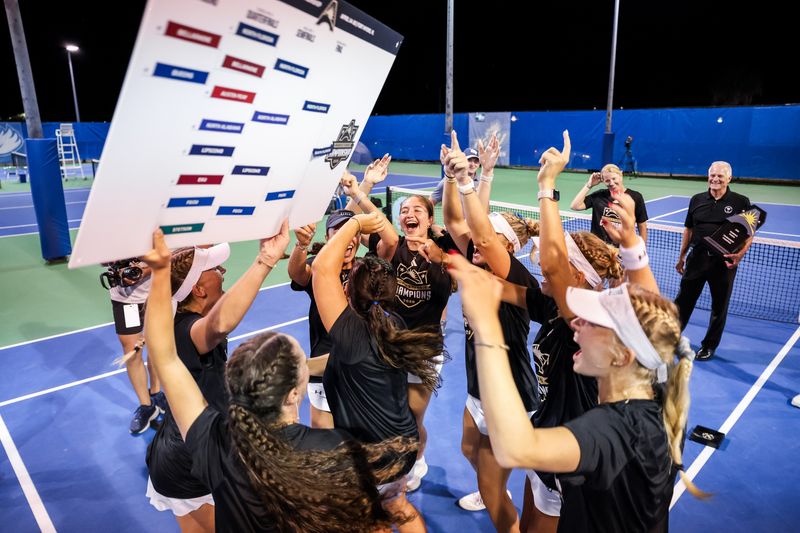 The University of North Florida women’s tennis team celebrates putting the school’s name in the champions slot of the ASUN tournament bracket on April 18 at the Florida Gulf Coast tennis complex in Fort Myers. It was UNF’s 11th ASUN championship