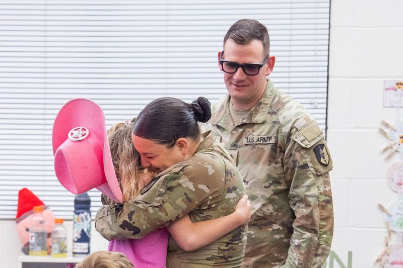 Brylee Garrity, 8, embraces her aunt, Kelsey Smith and uncle, Benjamin Hartley, who surprised her during class at DeSoto Elementary School on Monday, April 27, 2026. Smith and Hartley served more than 300 days overseas in the army and recently returned to the States.