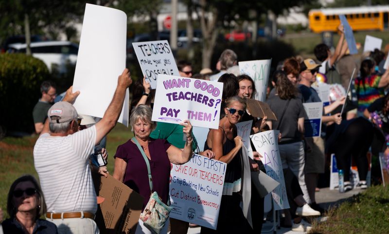 Protesters gather along Colonial Boulevard in front of the Lee County School District headquarters on Wednesday, April 29, 2026.