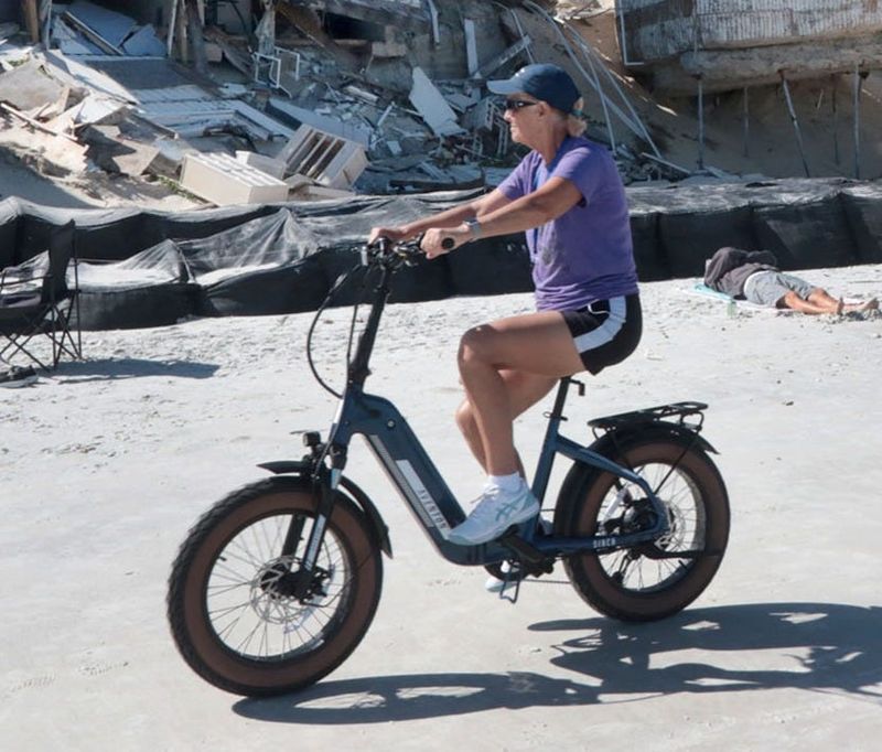 Beachgoers on e-bikes ride past the damaged homes in the 4100th block of South Atlantic Avenue Nov. 7, 2023, after Tropical Storm Nicole hit Volusia County.