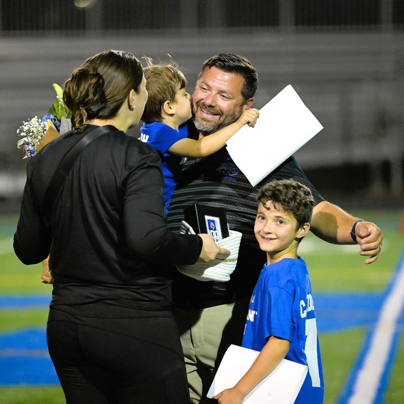 Wellington flag football head coach Robert Callovi celebrates his 100th win with his family following the Wolverines' regional victory over Jupiter on April 29, 2026.