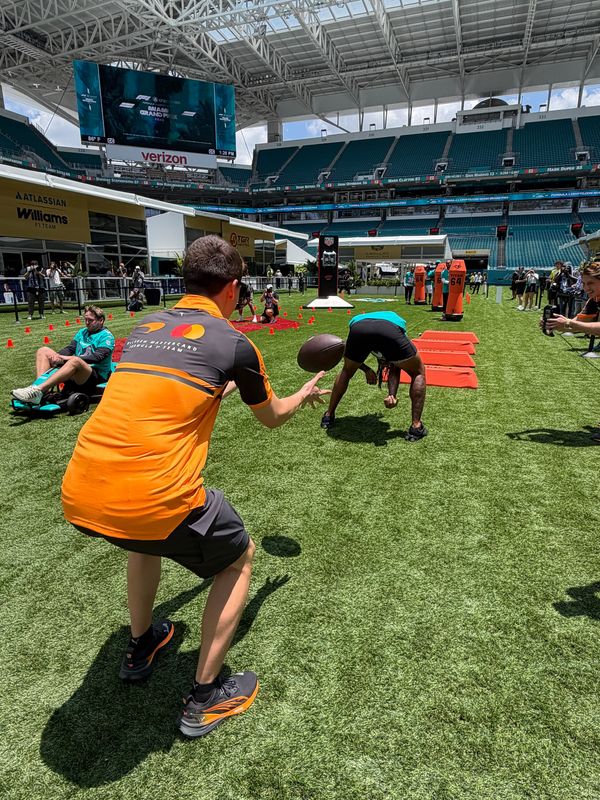 Miami Dolphins running back Ollie Gordon II tries his hand at snapping during an outing with Formula 1 drivers at the Miami Grand Prix on April 30, 2026.
