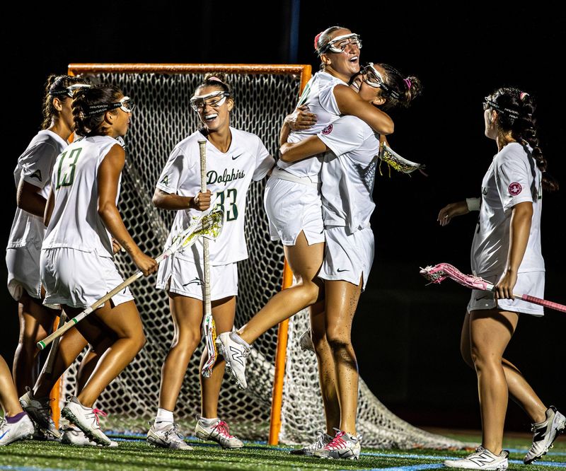 Jacksonville University women's lacrosse players celebrate their 17-3 ASUN Tournament semifinal victory over Liberty on April 30 at Rock Stadium in Jacksonville. The Dolphins will play Delaware on May 2 for the ASUN title at 1 p.m.