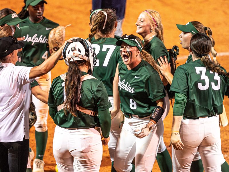 Members of the Jacksonville University softball team celebrate a 9-8 victory on May 1 over the University of North Florida, at JU's Pruitt Softball Complex.