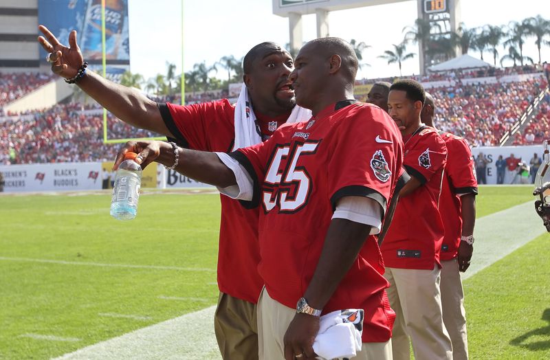 December 9, 2012; Tampa, FL, USA; Tampa Bay Buccaneers former player Warren Sapp (left) and former player Derrick Brooks talk on the sidelines during the first half against the Philadelphia Eagles at Raymond James Stadium.Former players of the 2002 super bowl championship team came back to celebrate their 10th anniversary. Mandatory Credit: Kim Klement-USA TODAY Sports
