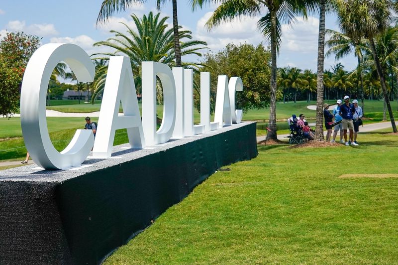 Fans watch from the shade near the 16th green during the first round of the Cadillac Championship golf tournament.