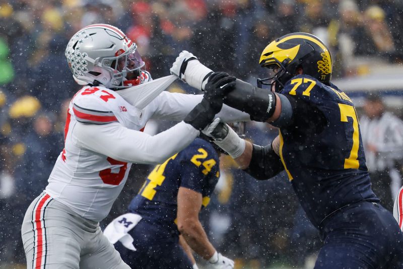 Nov 29, 2025; Ann Arbor, Michigan, USA; Michigan Wolverines offensive lineman Blake Frazier (77) blocks Ohio State Buckeyes defensive end Kenyatta Jackson Jr. (97) at Michigan Stadium. Mandatory Credit: Rick Osentoski-Imagn Images