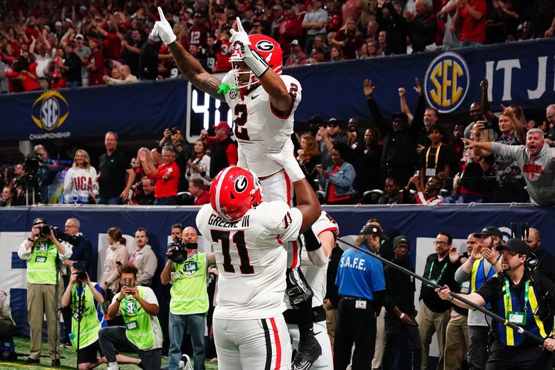 Dec 2, 2023; Atlanta, GA, USA; Georgia Bulldogs running back Kendall Milton (2) celebrates scoring a touchdown with offensive lineman Earnest Greene III (71) in the first quarter against the Alabama Crimson Tide in the SEC Championship at Mercedes-Benz Stadium. Mandatory Credit: John David Mercer-USA TODAY Sports