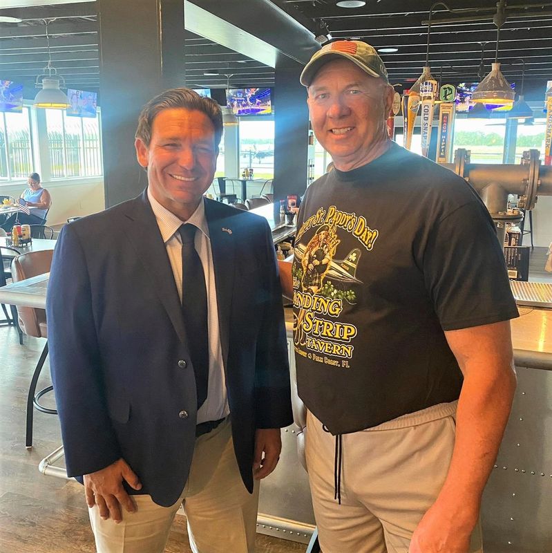 Florida Gov. Ron DeSantis poses for a photo with The Landing Strip Tavern Owner Jamie Bourdeau at the Palm Coast restaurant, Thursday, April 30, 2026.