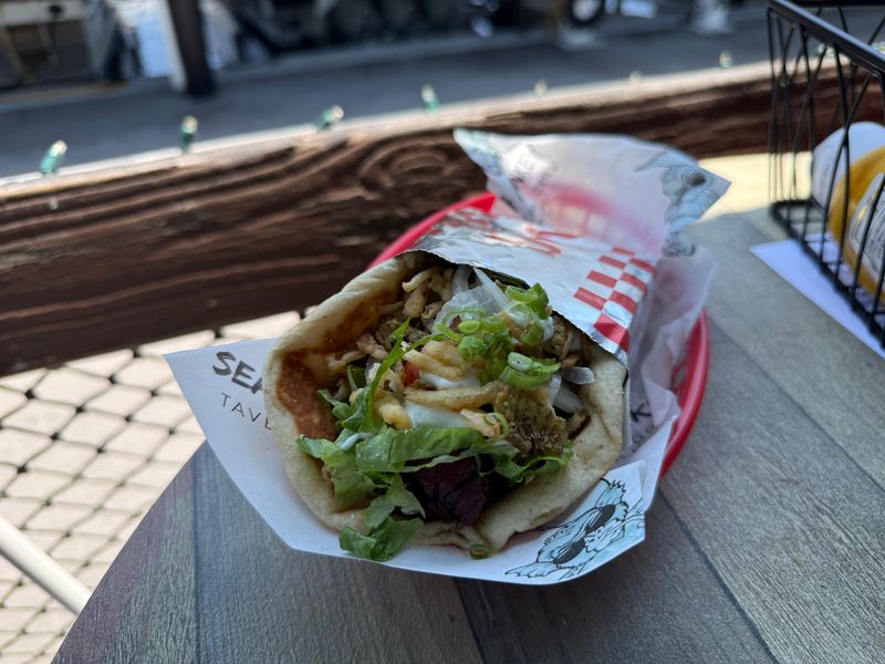 Sea Monkey Tavern's "Gyro Dog" was made with pita, lettuce, tomato, onion, onion crispies, tzatziki, and a bacon-wrapped hot dog.