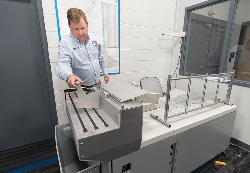 Escambia County Supervisor of Elections Robert Bender shows the extractor machine used to process mail-in ballots at the elections warehouse on Navy Boulevard in Pensacola on May 4, 2026.