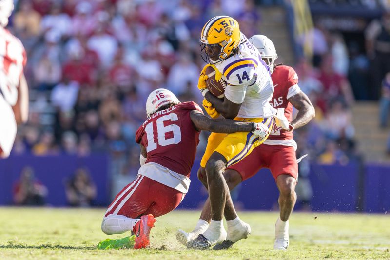 Nov 15, 2025; Baton Rouge, Louisiana, USA; Arkansas Razorbacks defensive back Miguel Mitchell (16) tackles LSU Tigers tight end Trey'Dez Green (14) during the second half at Tiger Stadium. Mandatory Credit: Stephen Lew-Imagn Images