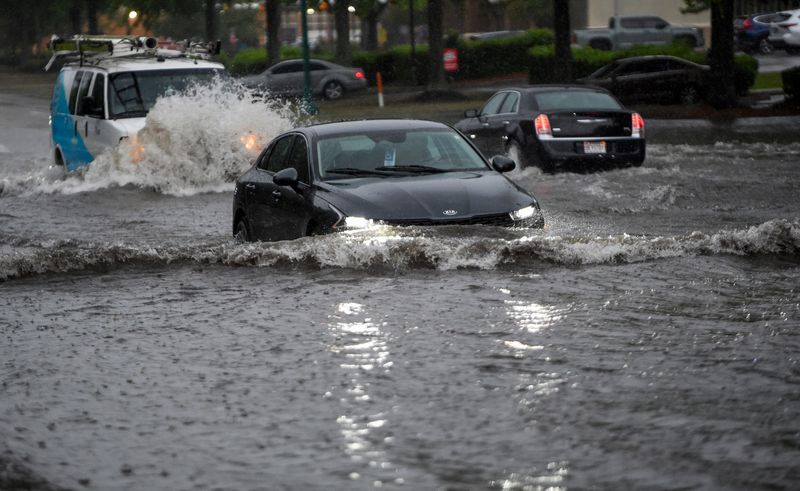 Vehicles drive through flooded roads as heavy rains and flash flooding are seen late Wednesday May 6, 2026 in Montgomery, Ala.