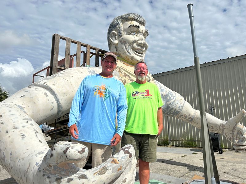 Clint Strand (right) and Stephen James have been repairing Cape Coral's hurricane-damaged Big John since removing the statue from its South Cape pedestal in November 2024. They're doing the work at Cape business Brand 1 Ink and hope the statue can return later in 2026.