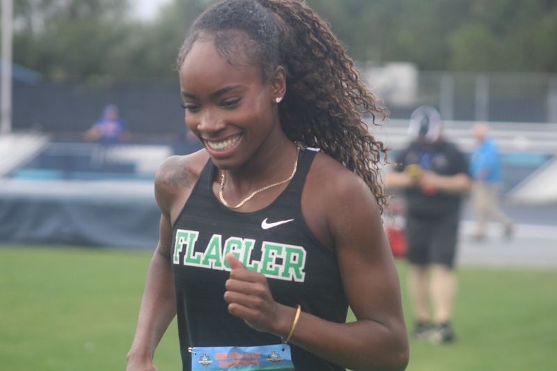 Flagler Palm Coast's Karina Marcelus smiles while heading to the podium to receive her medal for winning the triple jump during the FHSAA Class 4A track and field championships in Jacksonville on May 9, 2026.