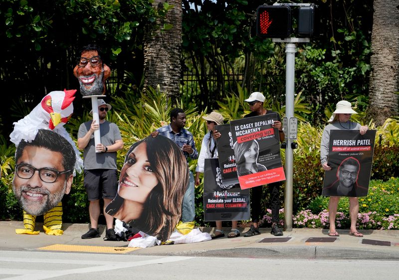 Demonstrators, including one wearing an inflatable chicken costume, line up along South County Road to protest Unilever over the welfare of chickens during the WWD Beauty CEO Summit at The Breakers May 11 in Palm Beach.