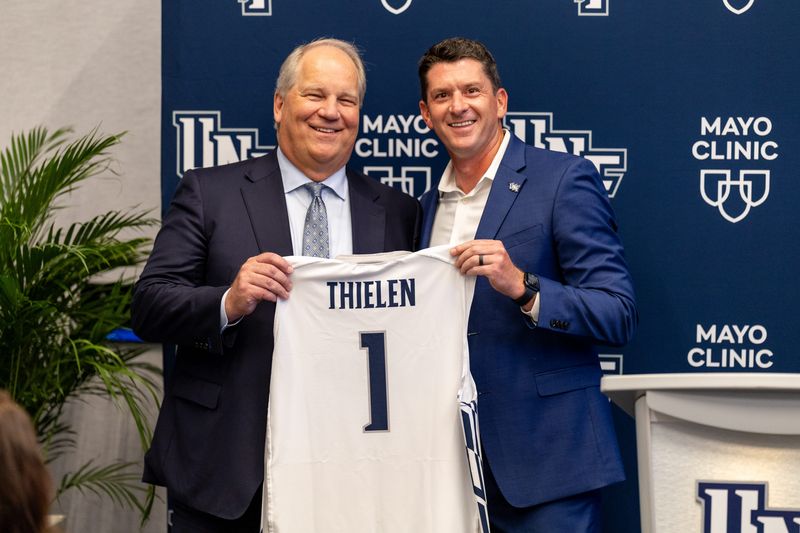 Mayo CEO Dr. Kent Thielen, left, receives a personalized University of North Florida jersey from Nick Morrow, UNF's vice president of intercollegiate athletics. Mayo was named UNF's Official Health Care Provider.