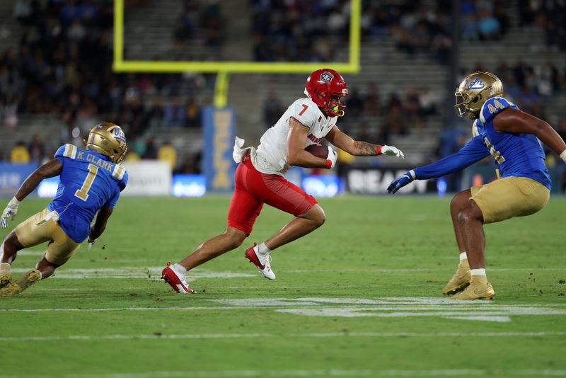 Sep 12, 2025; Pasadena, California, USA; New Mexico Lobos tight end Dorian Thomas (7) runs with the ball after making a catch as UCLA Bruins defensive back Kanye Clark (1) and defensive lineman Devin Aupiu (44) attempts to stop him during the fourth quarter at Rose Bowl. Mandatory Credit: Kiyoshi Mio-Imagn Images