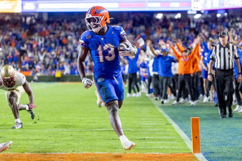 Nov 29, 2025; Gainesville, Florida, USA; Florida Gators running back Jadan Baugh (13) scores a touchdown during the fourth quarter against the Florida State Seminoles at Ben Hill Griffin Stadium. Mandatory Credit: Bob Kupbens-Imagn Images