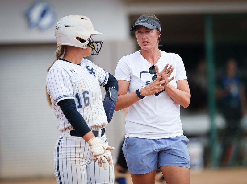 Santa Fe College Saints Softball player Molly Bender and head coach Savanah Webster discuss strategy during the team's matchup with St. Petersburg. The Saints open FCSAA DI Softball Championship regional play on May 13 against Miami Dade College.