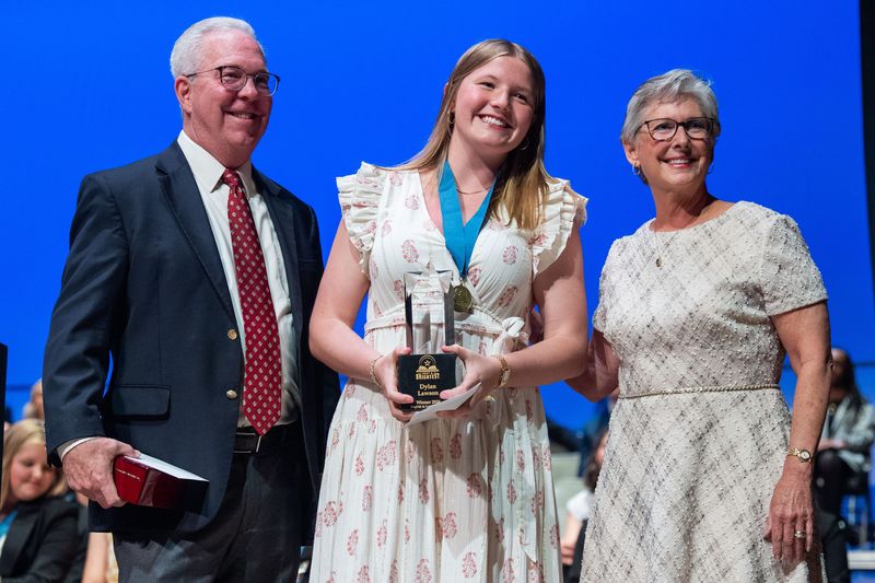 Dylan Lawson, center, receives the Spirit of the Best & Brightest Award, presented by Sam and Laura Rogers on Wednesday, May 13, 2026.