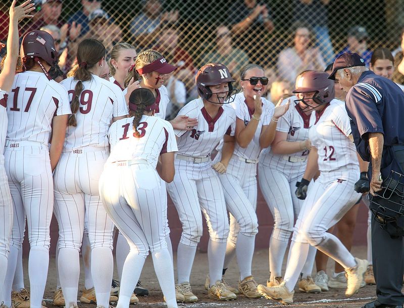 Niceville players greet Sydney Hann at the plate after she smashed a home run during the Niceville Gulf Breeze girls regional semi-final softball game at Niceville.