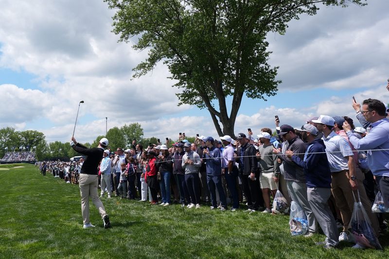 May 14, 2026; Newtown Square, Pennsylvania, USA; Rory McIlroy plays his shot on the fourth hole as spectators watch during the first round of the PGA Championship golf tournament at Aronimink Golf Club. Mandatory Credit: James Lang-Imagn Images