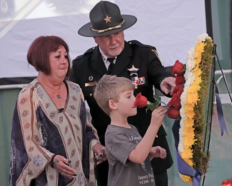 Sheriff Rick Staly and family members of fallen officers place flowers on a memorial wreath during a service honoring fallen law enforcement officers at the Flagler County Sheriff’s Office Operations Center in Bunnell on May 14, 2026.