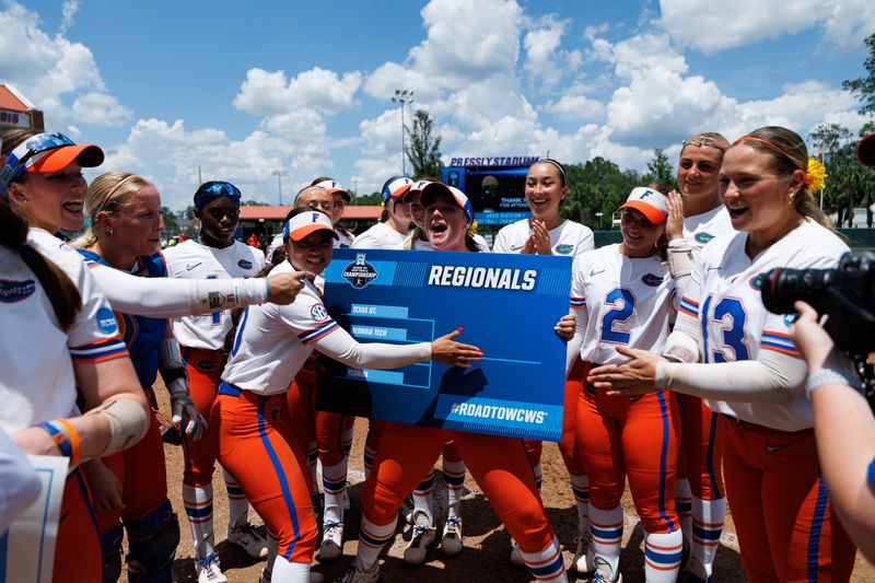 May 17, 2026; Gainesville, FL, USA; Florida Gators infielder Gabi Comia (10) and Florida Gators pitcher Caroline Stanton (1) celebrate with teammates placing the Florida sticker on the NCAA Regionals bracket after the game against the Georgia Tech Yellow Jackets at Katie Seashole Pressly Stadium. Mandatory Credit: Matt Pendleton-Imagn Images