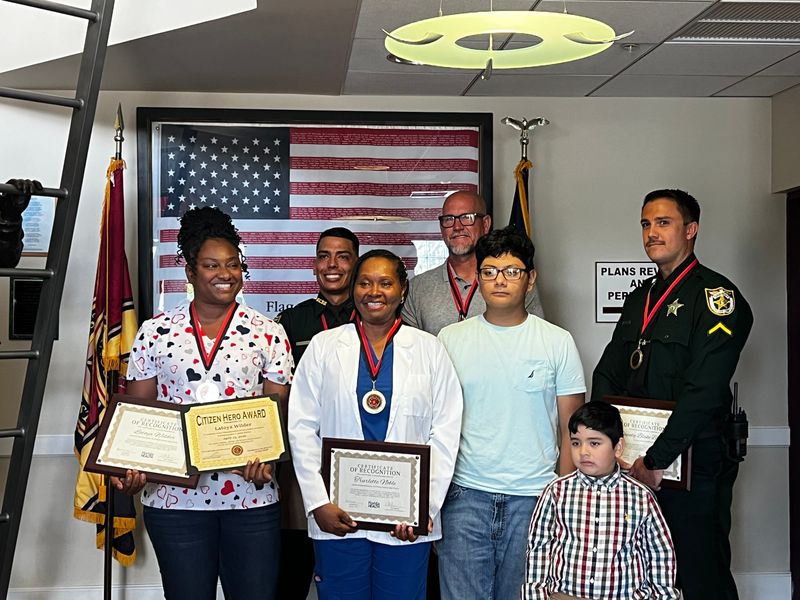 From left to right, Latoya Wilder, Robert-Daniel Lyons, Trurlette Noble, Michael Watkins, Eduardo Ortiz and Blake Behrsin, stand together after the St. Lucie County Fire District Hero Award ceremony on May 20, 2026. Eduardo's brother joined the group. Wilder, Noble and Watkins, Fort Pierce Central High School staff members, received the Citizen Hero Award while St. Lucie County Sheriff's Deputies Lyons and Behrsin received the Public Safety Hero Award for providing lifesaving emergency support to Ortiz, 16, during a cardiac arrest emergency on April 23, 2026.