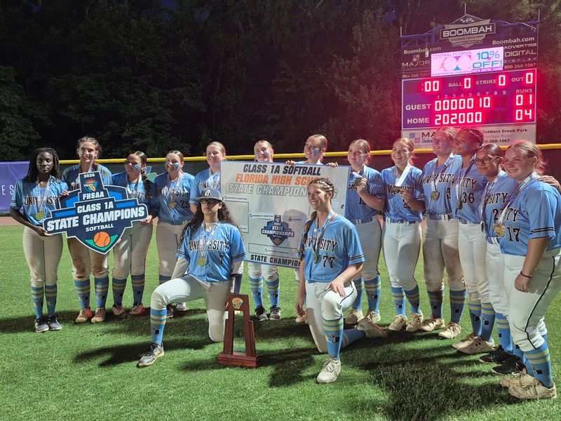 University Christian players celebrate with the trophy after defeating Geneva in the Class 1A softball final on May 20, 2026.