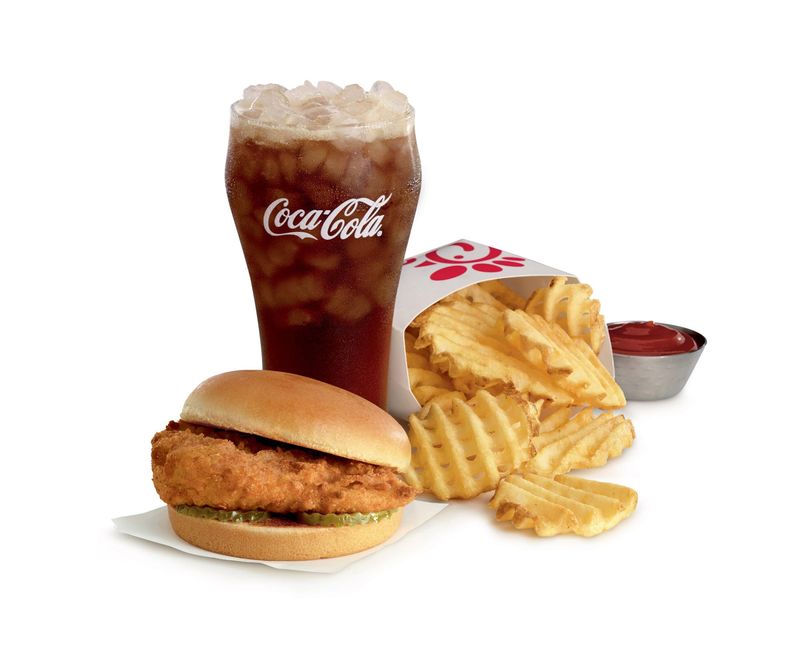 A meal from Chick-fil-A featuring a chicken sandwich, Coca-Cola and waffle fries.