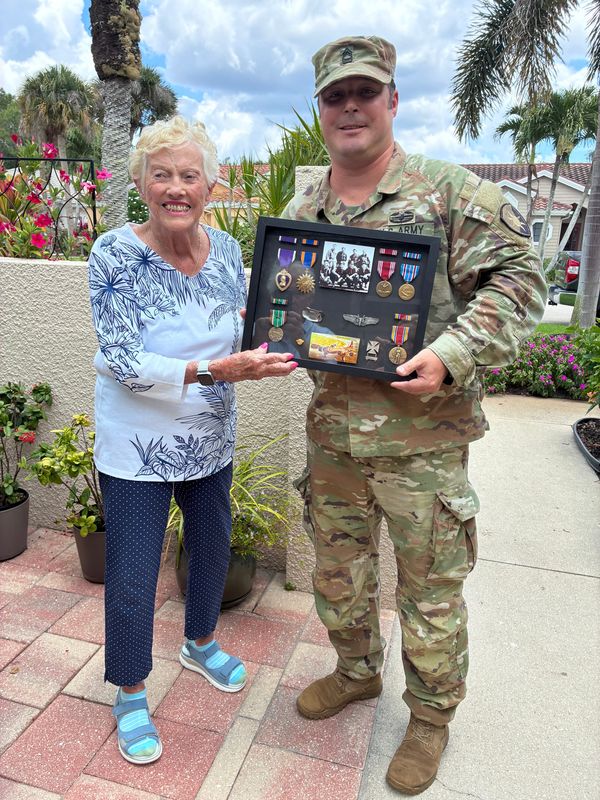 Bonnie Rolquin, 98, displays medals posthumously awarded to her cousin, Tech. Sgt. Charles C. Palmer. He was killed during WWII. With her is Master Sgt. Rory Kamenicky with the U.S. Army who delivered the medals and had a shadow box made.