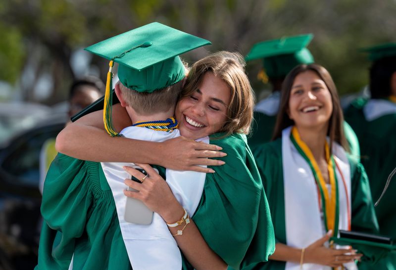 A graduate gets a hug after the Suncoast High School graduation ceremony at the South Florida Fairgrounds on May 21, 2026, in suburban West Palm Beach, Florida.