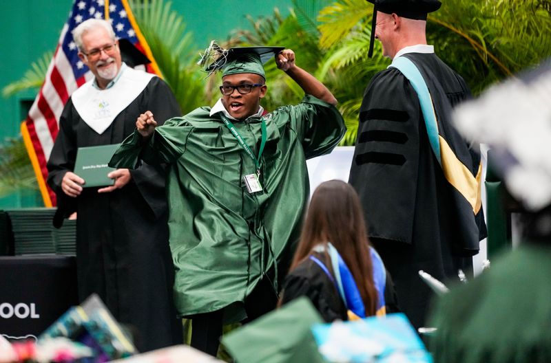 Owen Burgess dances on stage while receiving his diploma during the commencement ceremony for the Class of 2026 at Palmetto Ridge High School in Naples, Fla., on Thursday, May 21, 2026.