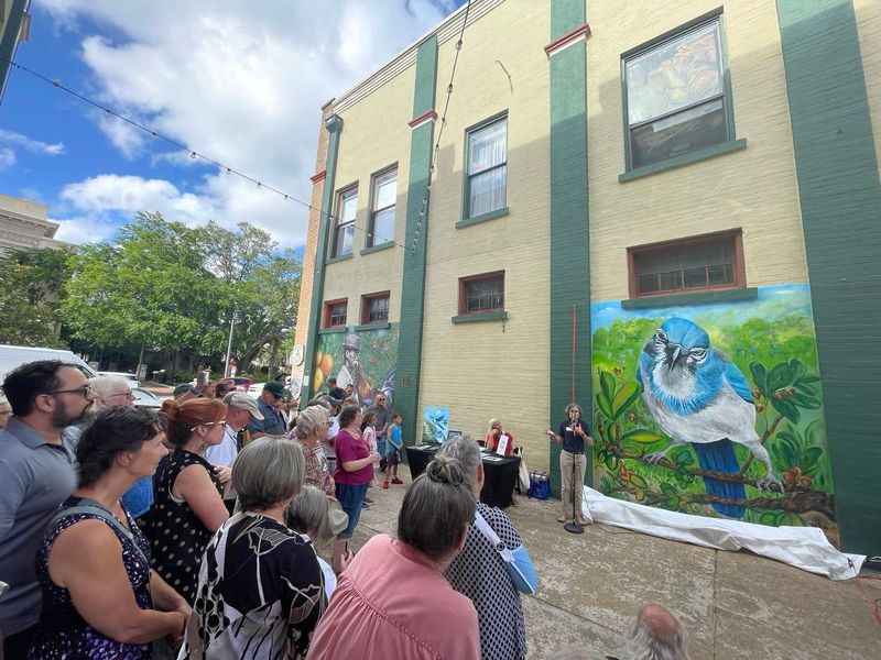People gather for the unveiling of a scrub jay mural in DeLand on May 19.