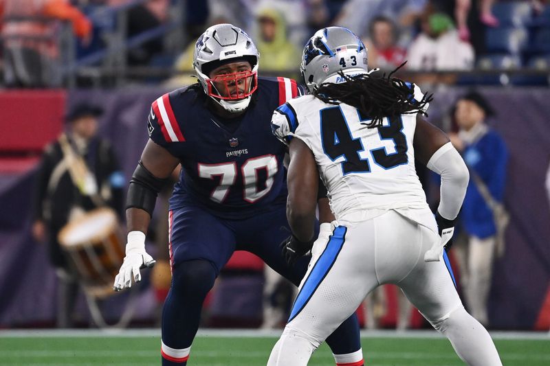 August 8, 2024; Foxborough, MA, USA; New England Patriots offensive tackle Caedan Wallace (70) lines up with Carolina Panthers linebacker Luiji Vilain (43) during the first half at Gillette Stadium. Mandatory Credit: Eric Canha-USA TODAY Sports
