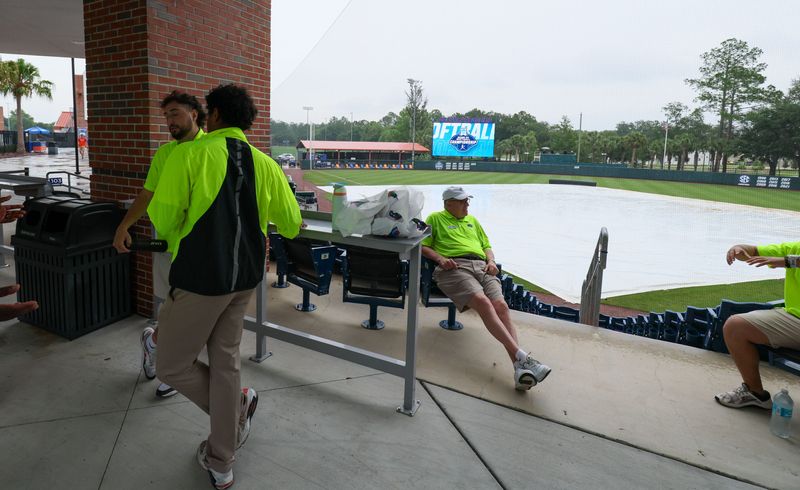 Staff waits for the rain to let up and fans to be let into the stadium before game 2 of the super regional of the NCAA Division 1 softball championship at Katie Seashole Pressly Stadium in Gainesville, FL on Saturday, May 23, 2026. [Alan Youngblood/Gainesville Sun]