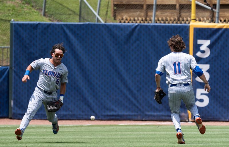 A fly ball falls between Florida Gators' Blake Cyr (5) and Florida Gators' Brendan Lawson (11) as Georgia Bulldogs take on Florida Gators during the SEC baseball tournament at Hoover Metropolitan Stadium in Hoover, Ala. on Saturday, May 23, 2026.