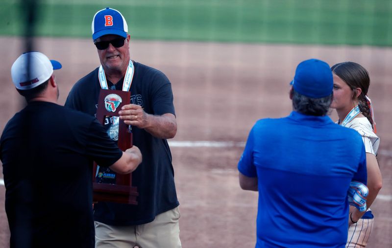 Bartow head coach Glenn Rutenbar receives the state runnerup trophy after the Class 6A state championship game.