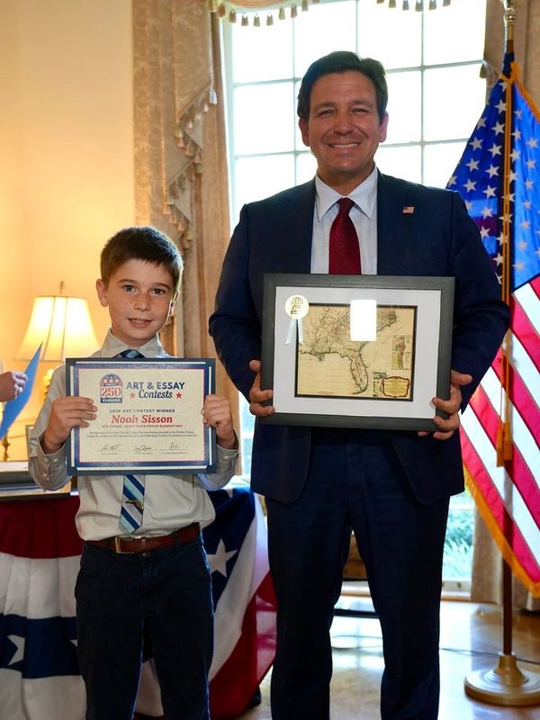 Noah Sisson, a fourth-grade student at Highlands Grove Elementary School in Lakeland, with Gov. Ron DeSantis in the Governor's Mansion in Tallahassee after Sisson won the America250FL art and essay contest.
