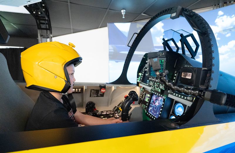 Gannon Wright, 8, of Pekin, Indiana, sits in a full-scale replica cockpit of a Blue Angels F/A-18 Super Hornet as he pilots the new “Fly with the Blues” interactive simulator at the National Naval Aviation Museum in Pensacola on May 27, 2026.