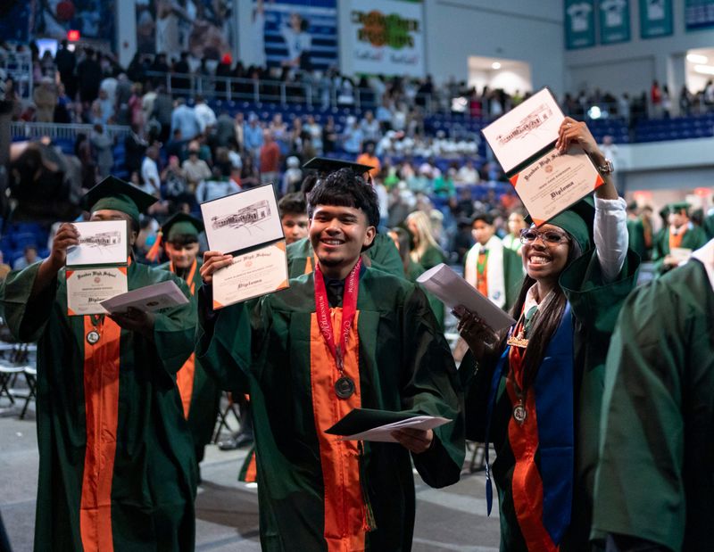 From left: Marion Raphael, Juan Raymundo Itzel and Imani Robinson show their diplomas during the commencement ceremony for the Dunbar High School Class of 2026 at Suncoast Credit Union Arena in Fort Myers, Fla., on Saturday, May 30, 2026.