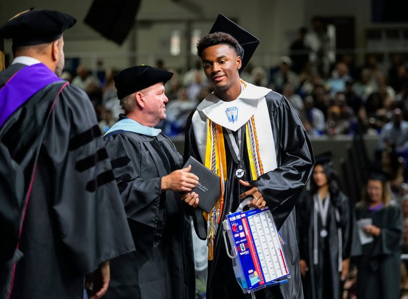Ryan Hunter receives his diploma while carrying a medical chest drainage system during the commencement ceremony for the Mariner High School Class of 2026 at Alico Arena in Fort Myers, Fla., on Sunday, May 31, 2026. Hunter was transported to the ceremony by Golisano Children’s Hospital staff where he’s recovering after a lung collapse.